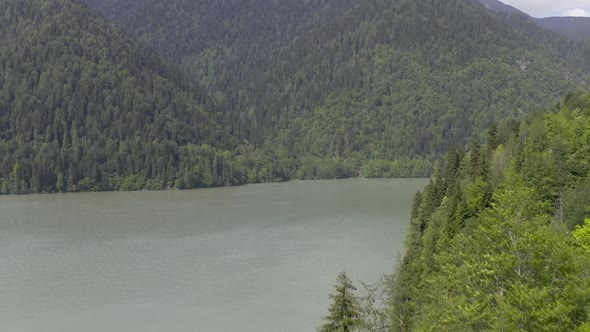 Aerial Shot Natural Landscape with Lake Ritsa in Abkhazia Surrounded By Mountain Hilly Terrain