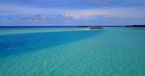 Wide angle fly over clean view of a white sand paradise beach and blue ocean background in hi res 4K