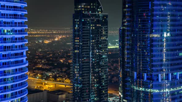 Buildings of Jumeirah Lakes Towers with Traffic on the Road Aerial Night Timelapse