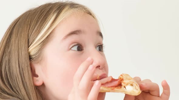 Portrait of a Child of a Girl Who Eats Delicious Pizza and Opens Her Eyes in Surprise