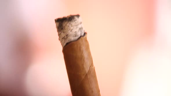 Extreme close up of someone holding and smoking a cigar in the Caribbean
