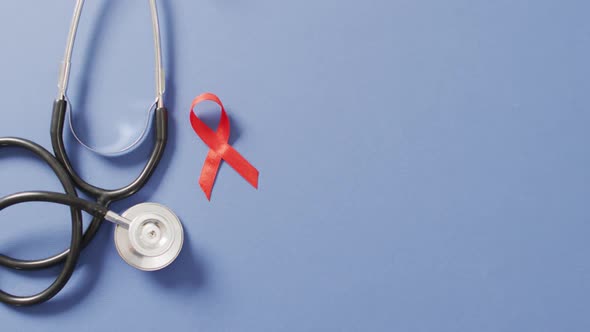 Video of stethoscope and red blood cancer ribbon on blue background