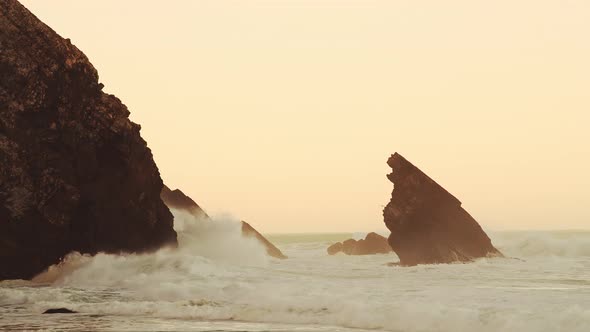 Waves Crashing Against Rocks at Orange Sunrise, Beautiful Rugged Rocky Coastal Scenery and Coastline