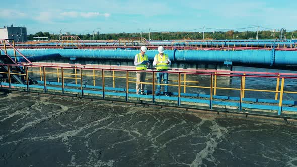 Industrial Workers are Observing Sewage Water Flowing Around