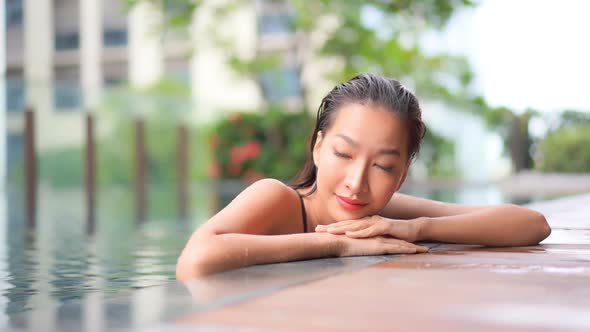 Young asian woman enjoy around outdoor swimming pool for leisure