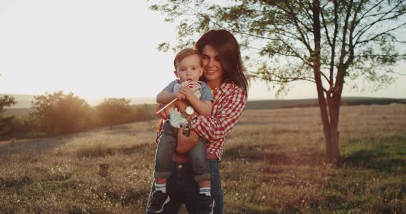 Young Mother with Her Baby Boy, at Sunset