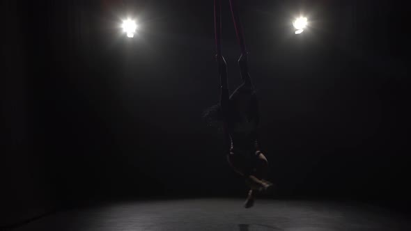 Girl Dancing with Aerial Silk Flying Wings in Black Background