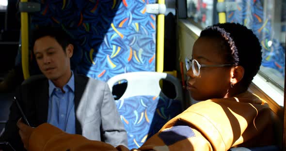 Female commuter using mobile phone while travelling in bus 4k