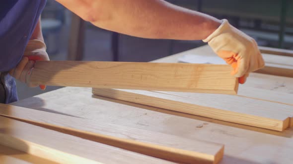 Carpenter arranging wood planks