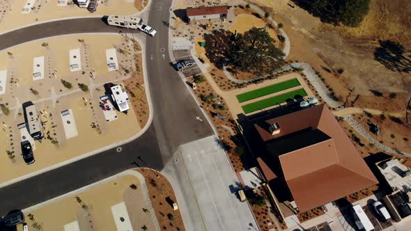 Aerial fly through of an RV Park at Sunset showing the entrance and RV spots and pool area.