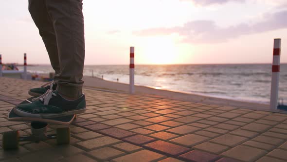 Close Up Shot of Young Man Skateboarding on the Road Near the Sea Slow Motion