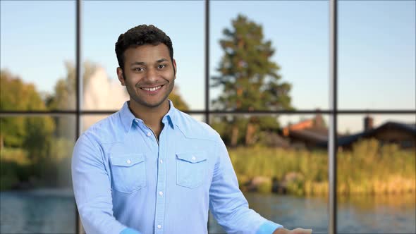 Young Attractive Man Presenting Something with Hands.