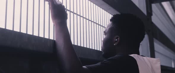 Young Black Man in front of a fence