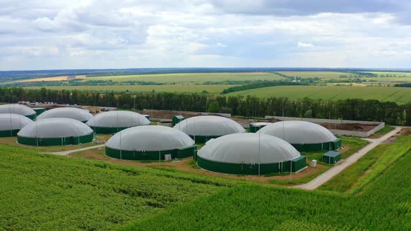 Round storage tanks for biogas. Biogas production on green landscape background. 