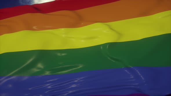 Rainbow Flag of an LGBT Organization Waving Against a Blue Sky