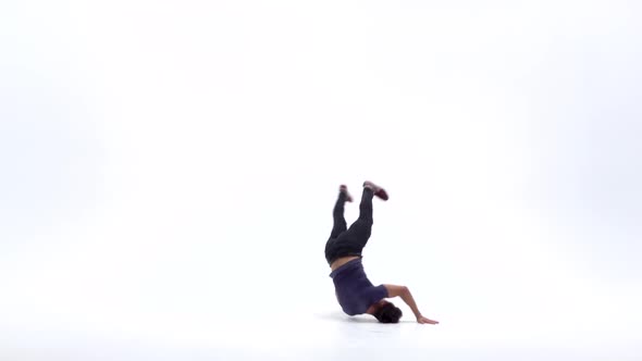 Man Is Dancing Breakdance on the White Background in Simple Grey T-shirt and Grey Jeans. Slow Motion