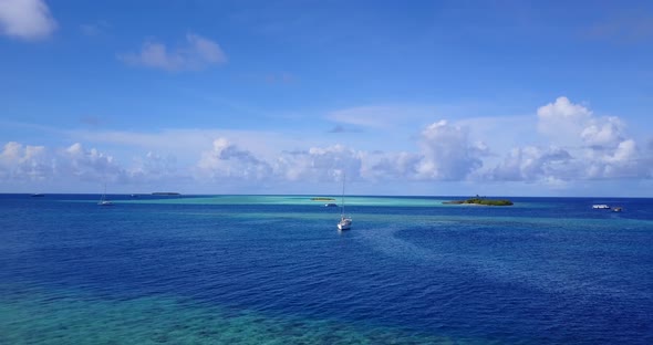 Beautiful fly over island view of a white sandy paradise beach and aqua blue water background in vib