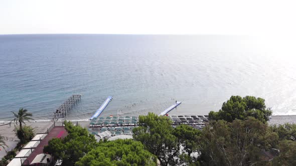 Aerial View of Endless Calm Sea in the Sun with Floating Plastic Piers and Rows of Sun Loungers with