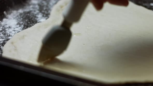 Greasing the Heart Shaped Dough with Olive Oil to Cook the Tuna Pizza