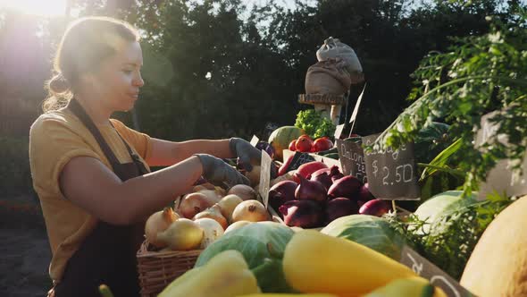 Woman Farmer Prepares the Grocery Counter at the Farmers Market