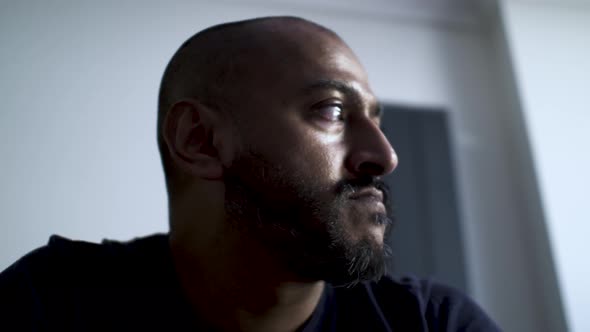 Bald Ethnic Minority Male Looking Out Sideways Pensively Thinning. Low Angle, Locked Off