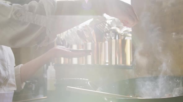 Chef adding salt on the vegetables