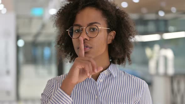Serious African Businesswoman Putting Finger on Lips Quiet Sign