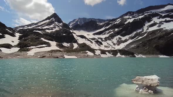 Walking towards a beautiful blue lake with snow and ice in the Austrian Alps, Uttendorf Weissee