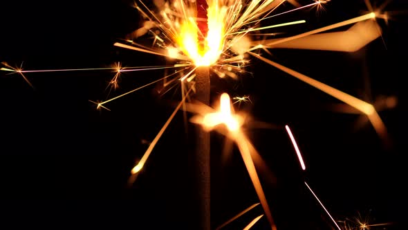 Burning sparkler close up on black background. Burning New Year sparklers. 4K UHD video