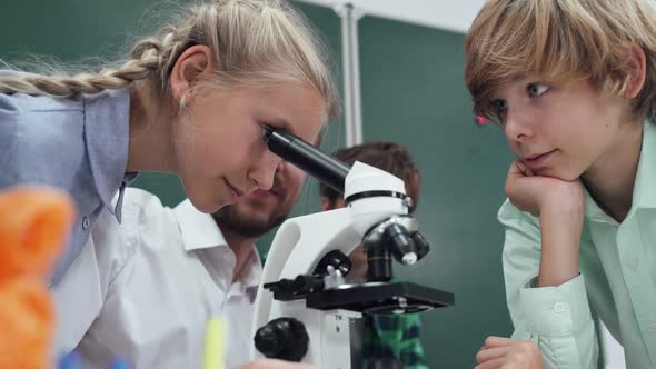 Lesson in a Modern School a Teacher and Children's Look Into a Microscope Studying Biology and