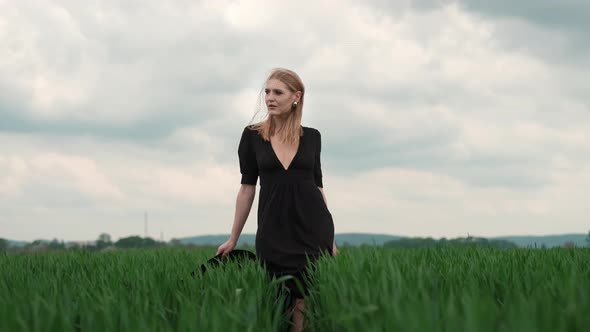 Flamboyant Girl In Black Dress Goes By The Field.