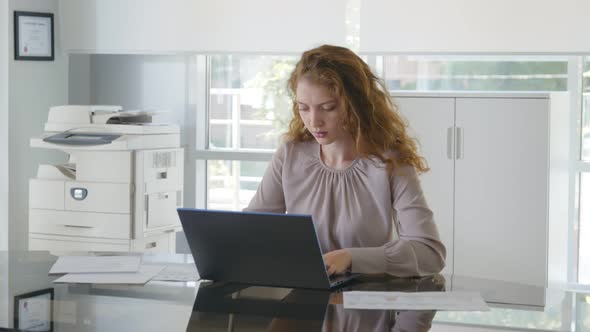 Young Businesswoman Sitting on Workplace in Office Working on Laptop