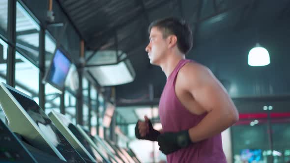 Caucasian young sportsman workout exercise by running on treadmill machine for health in fitness gym