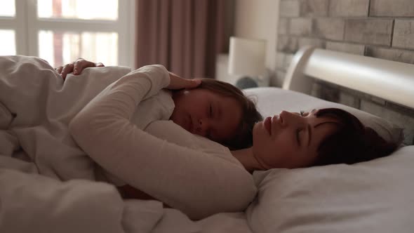 A Nice Girl and Her Mother Enjoy Sunny Morning While Sleeping Together