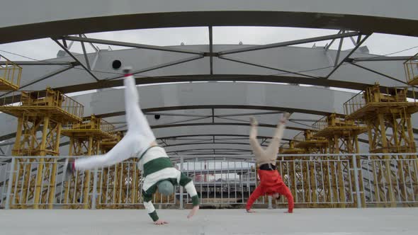 Two Parkour Athletes Performing Cartwheel and Side Flip