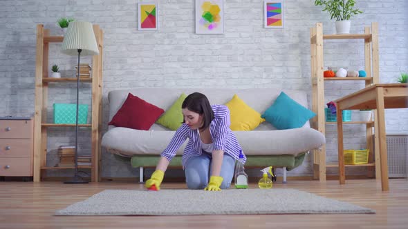 Young Woman in Gloves Is Happy To Clean the Carpet with Her Hands