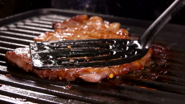 Delicious Meat Steak Is Pressed with Kitchen Spatula To the Grill