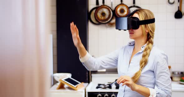 Woman using virtual reality headset in kitchen