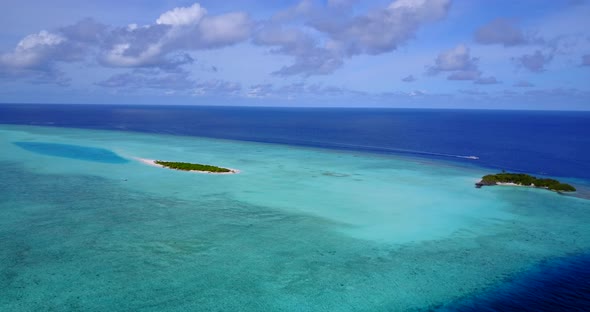 Wide above travel shot of a white paradise beach and blue sea background in colorful 4K