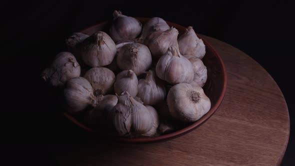 Pile of Whole Bulbs of Garlic in Ceramic Bowl on Table