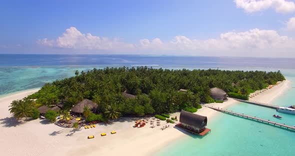 Aerial drone view of a scenic tropical island resort hotel in the Maldives