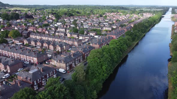 Aerial view flying above wealthy Cheshire housing estate alongside Manchester ship canal slow descen