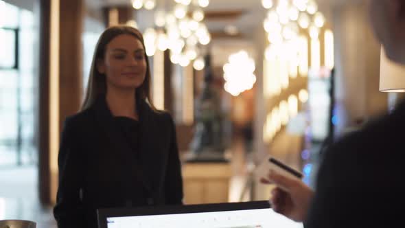 Business Woman Goes to Reception of Hotel and Receives a Key Card From the Room Woman in Business