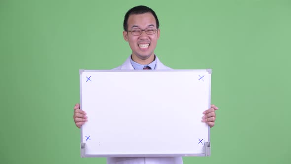 Happy Asian Man Doctor Holding White Board