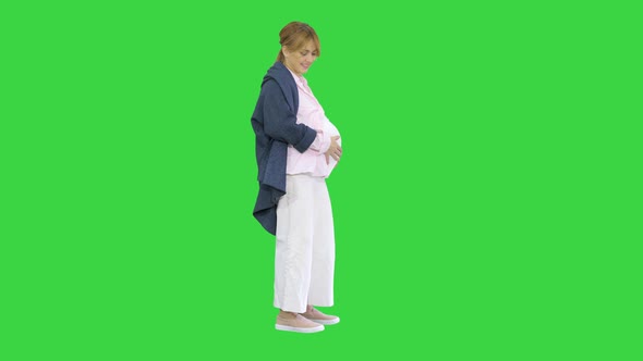 Pregnant Woman Caressing Her Belly on a Green Screen, Chroma Key.