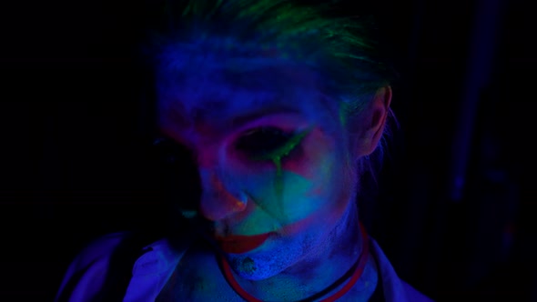 Closeup of Face of Young Woman with Scary Makeup By Fluorescent Paints Female Portrait in Darkness