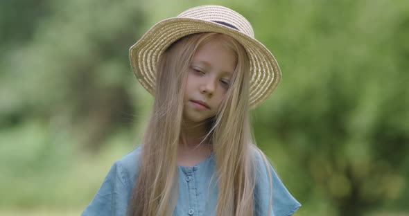 Portrait of Beautiful Little Girl on a Blurred Nature Background, a View of a Girl Smiling Face