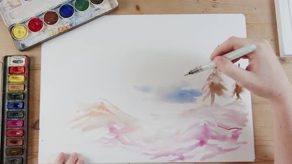 Timelapse of artist painting landscape with watercolors