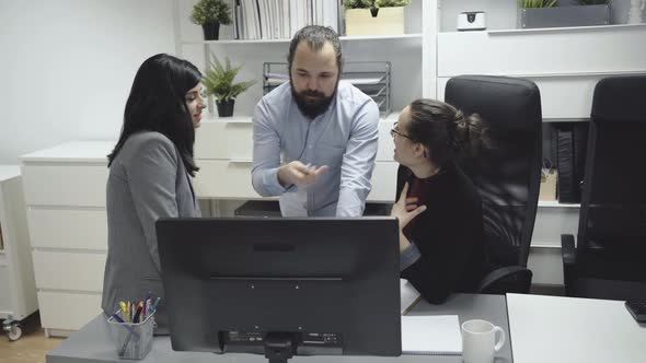 Business colleagues discussing data on computer