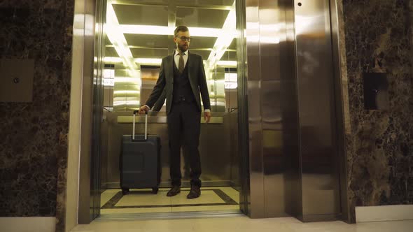 Young Man in Suit Carrying a Suitcase Enters in the Elevator Business Trip